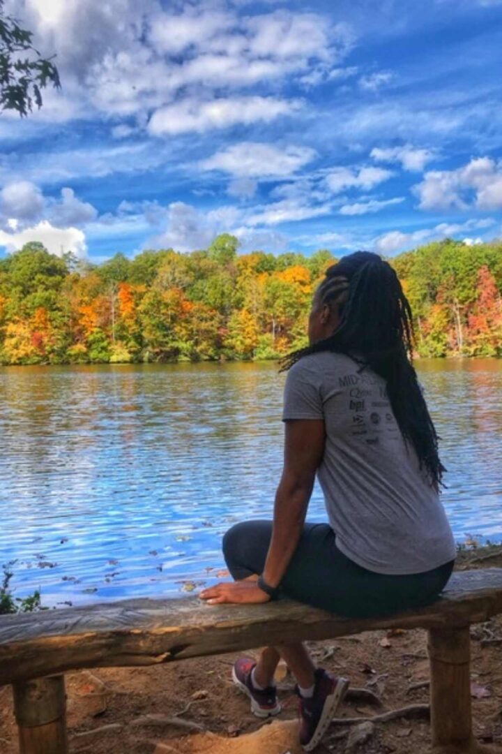woman sitting at lake while hiking paris mountain state park