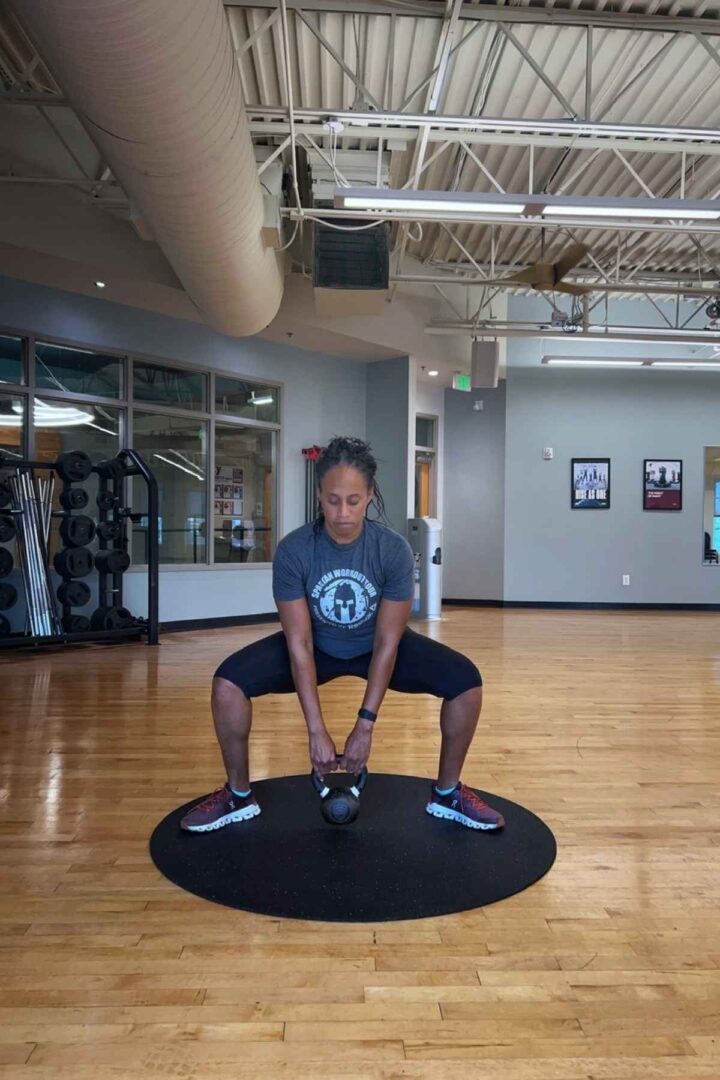 woman doing goblet kettlebell leg exercise in the gym