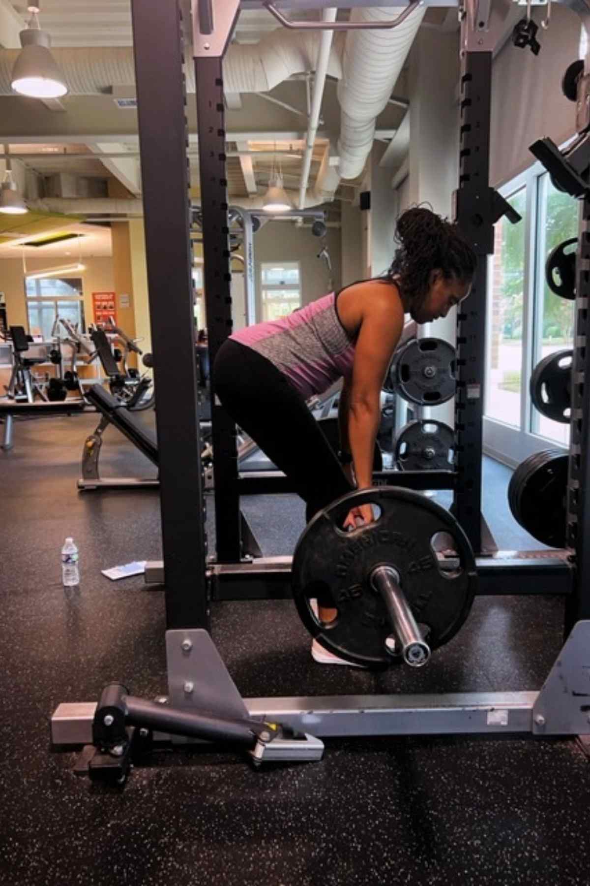 woman preparing for rack pull exercise in squat rack