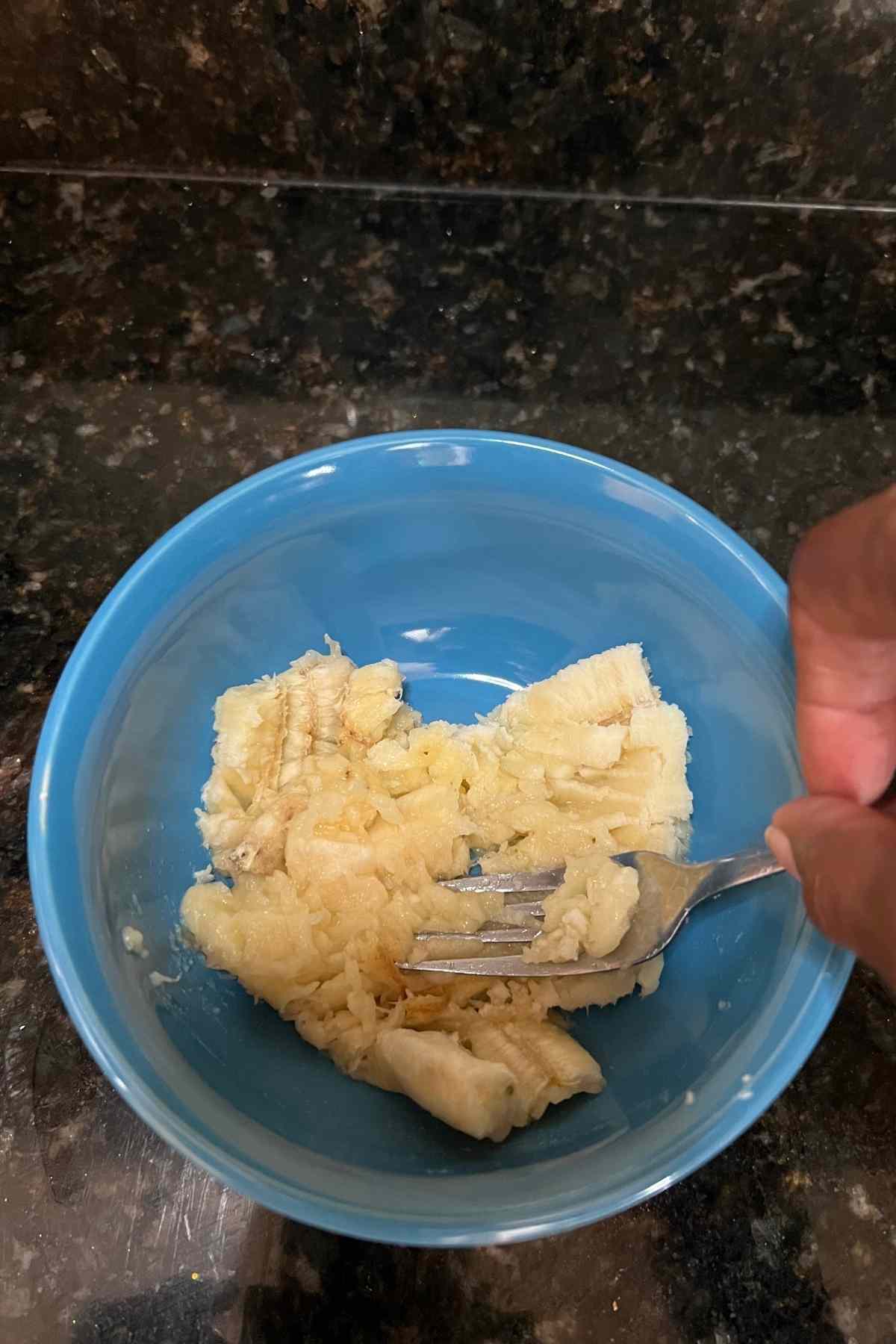 a banana mashed in a blue bowl