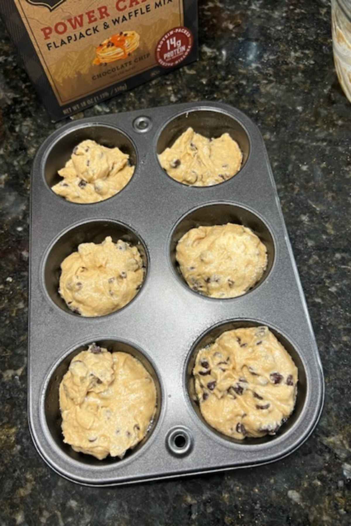 kodiak cake chocolate chip muffins batter in tin on counter