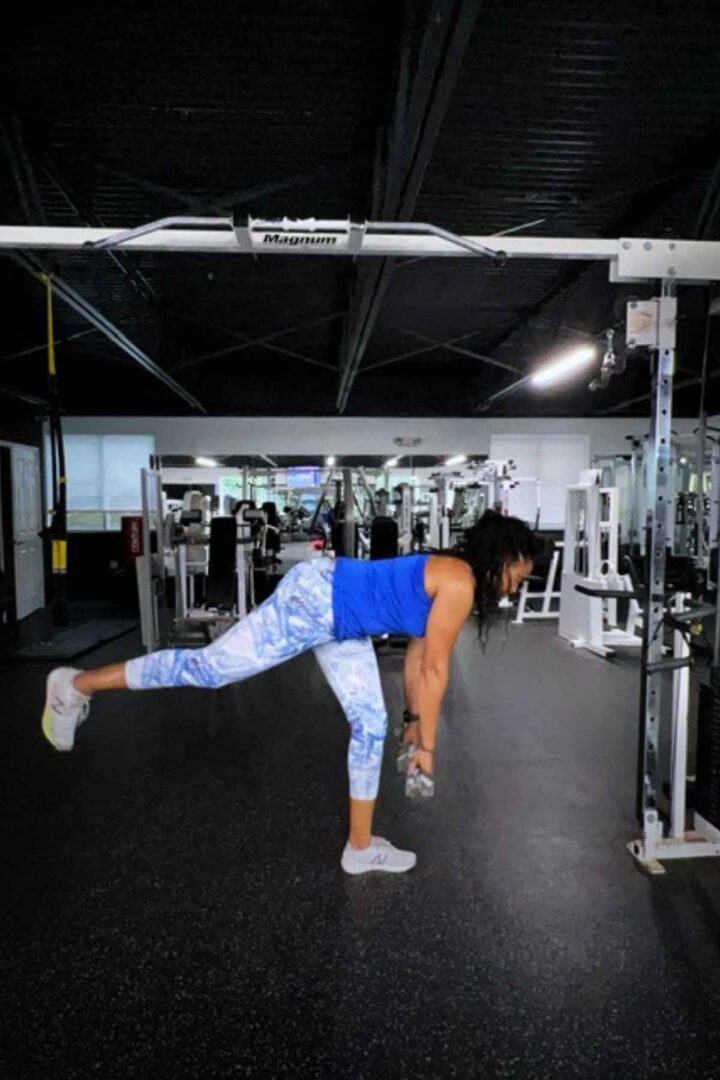 woman in blue tank top and leggings doing single leg deadlift which is a great hamstring exercise for runners
