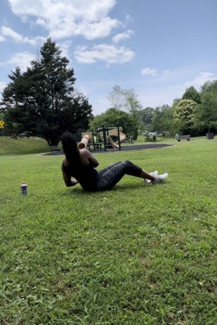 woman doing russian twists in the park. they are a great beginner no equipment core exercise