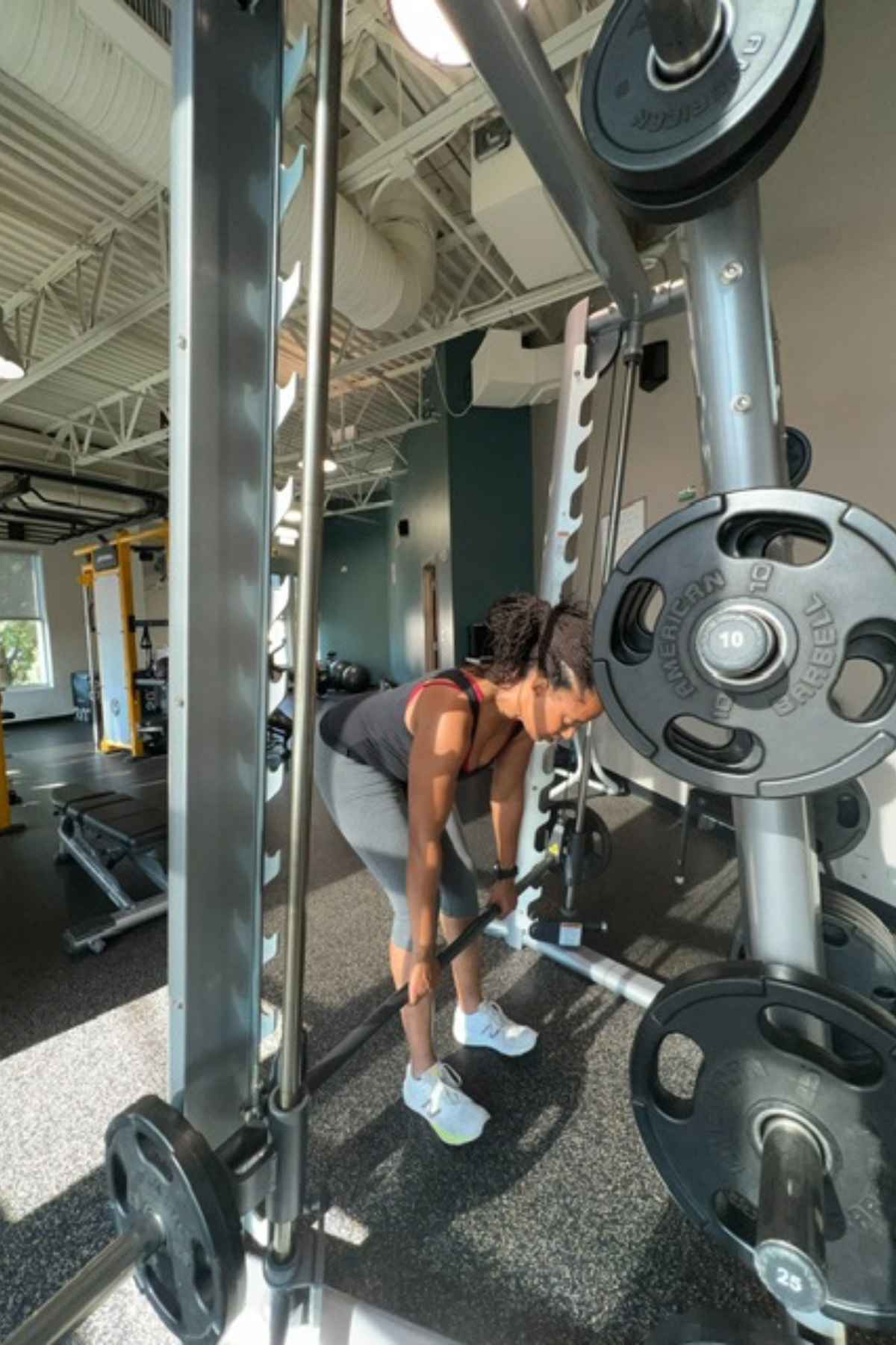 woman doing smith machine deadlifts in the gym