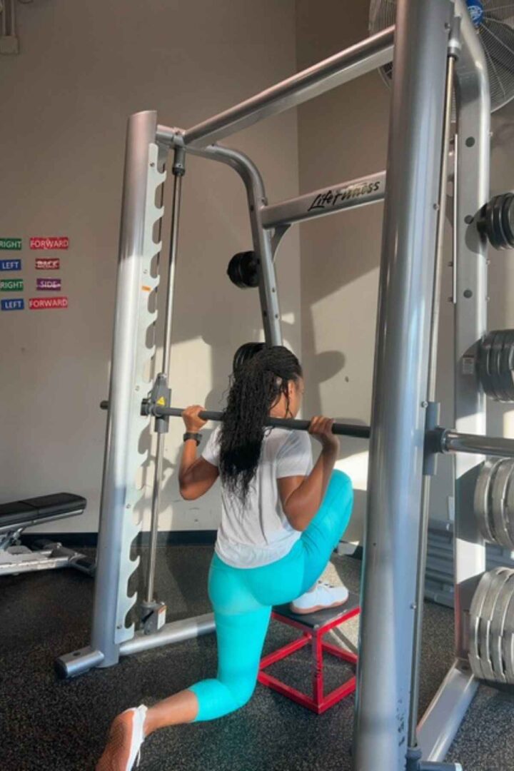 woman doing smith machine deficit lunges