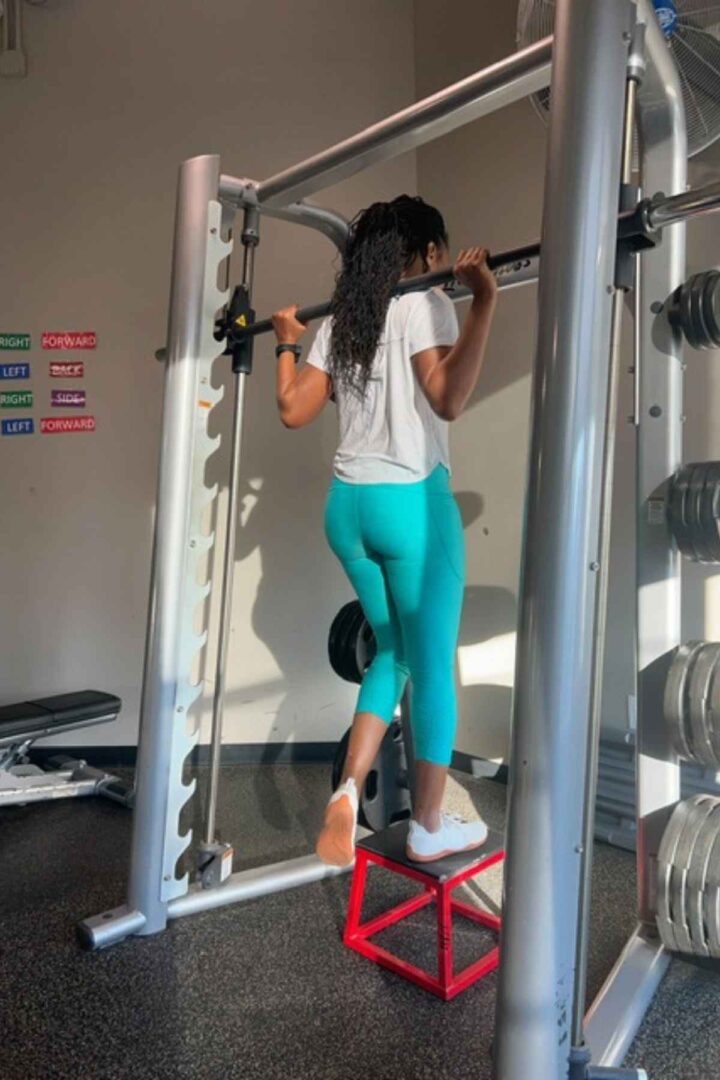 woman doing smith machine deficit lunges