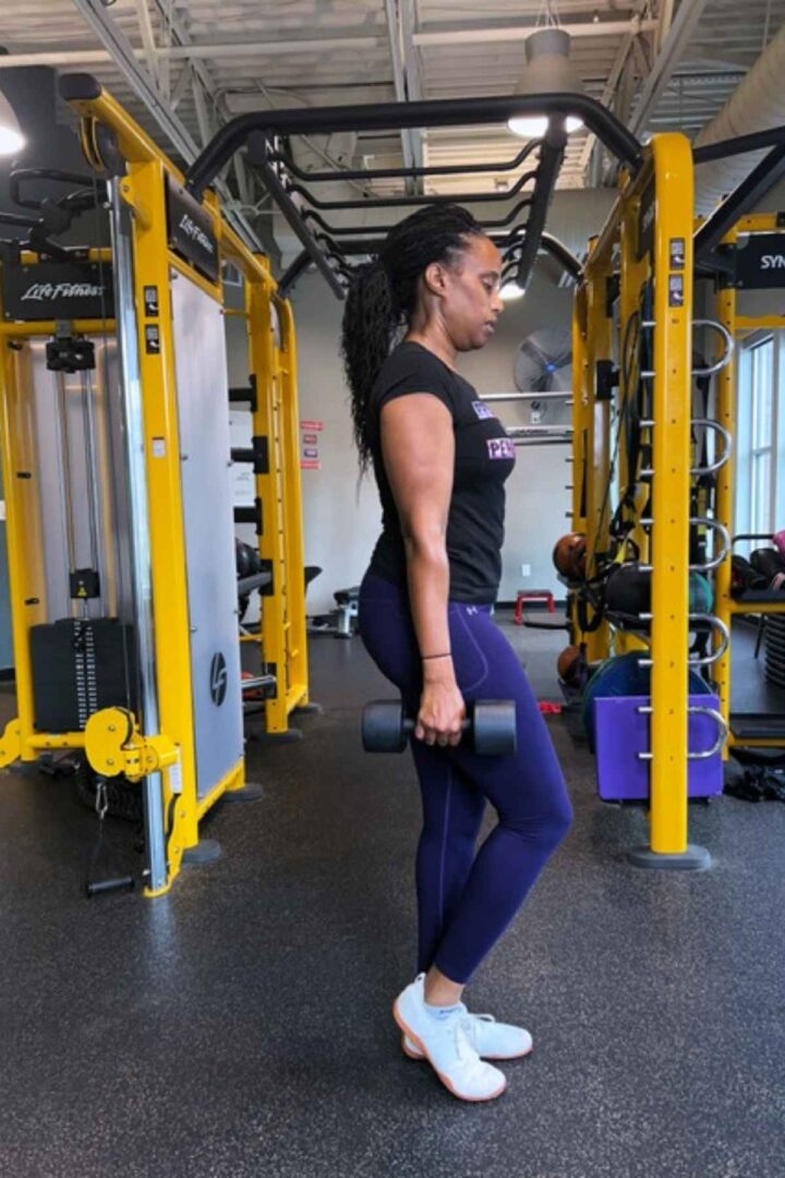 woman in purple leggings doing walking lunges across the gym